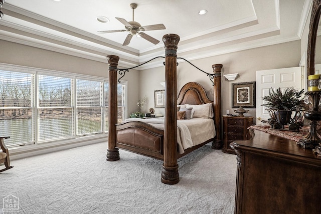 bedroom with carpet, a tray ceiling, and ornamental molding