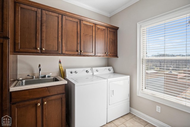 laundry room featuring light tile patterned floors, a sink, ornamental molding, cabinet space, and washing machine and clothes dryer