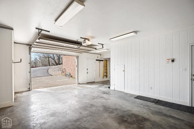garage with wooden walls and a garage door opener