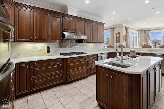 kitchen featuring under cabinet range hood, a sink, gas cooktop, and plenty of natural light