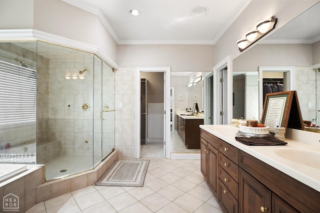 full bath with a shower stall, crown molding, double vanity, and a sink