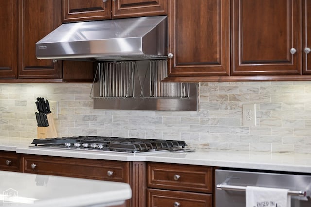 kitchen featuring stainless steel appliances, under cabinet range hood, light countertops, and decorative backsplash