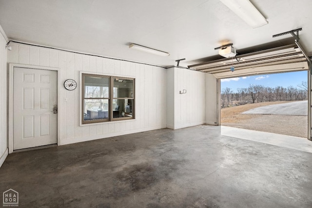 garage with baseboards and a garage door opener