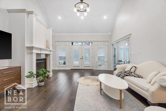 4024 Chapel Hill Dr, Jonesboro, AR 72404 - living room with dark wood finished floors, high vaulted ceiling, crown molding, a fireplace, and recessed lighting