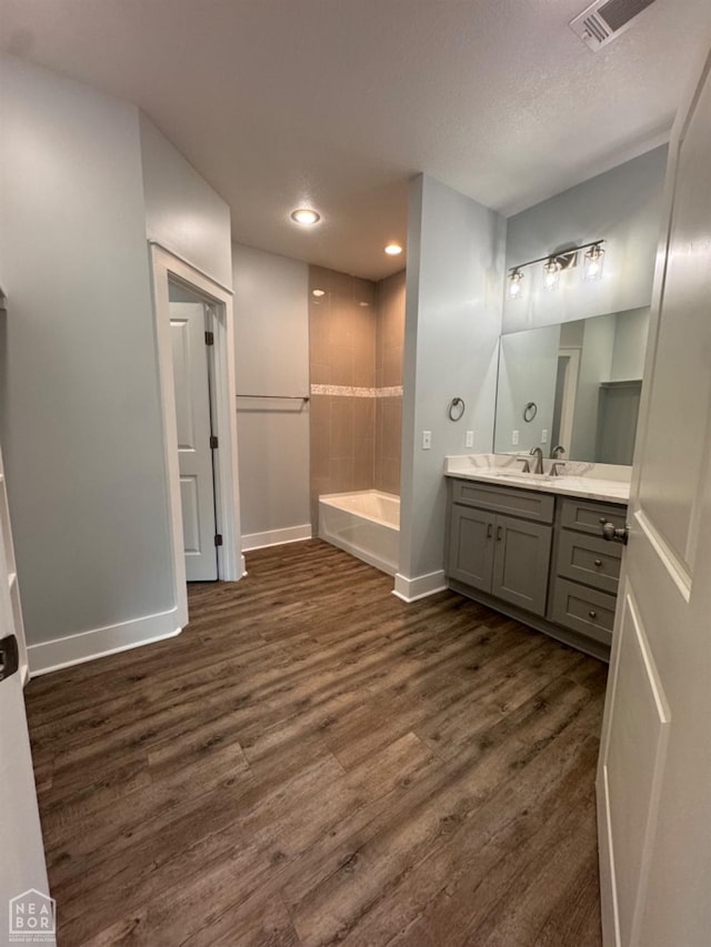210 E College St, Bono, AR 72416 - bathroom featuring wood finished floors, a bath, baseboards, vanity, and recessed lighting