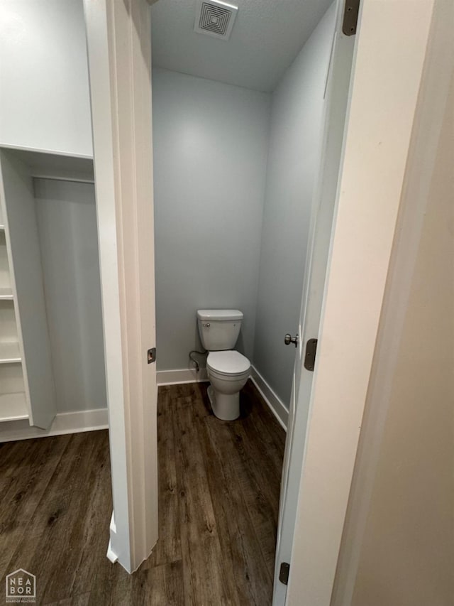 210 E College St, Bono, AR 72416 - bathroom featuring wood finished floors, toilet, and baseboards