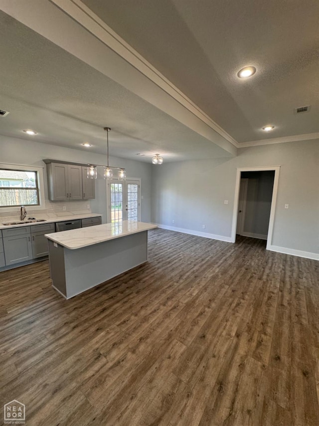 210 E College St, Bono, AR 72416 - kitchen featuring gray cabinets, a kitchen island, a sink, open floor plan, and baseboards