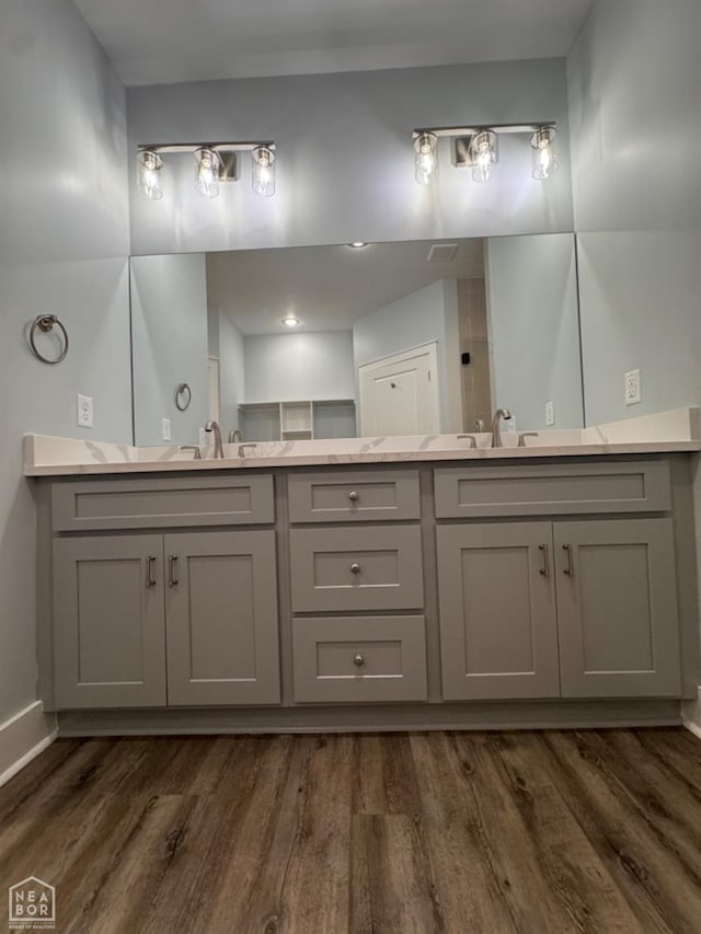 210 E College St, Bono, AR 72416 - bathroom featuring wood finished floors, double vanity, and baseboards