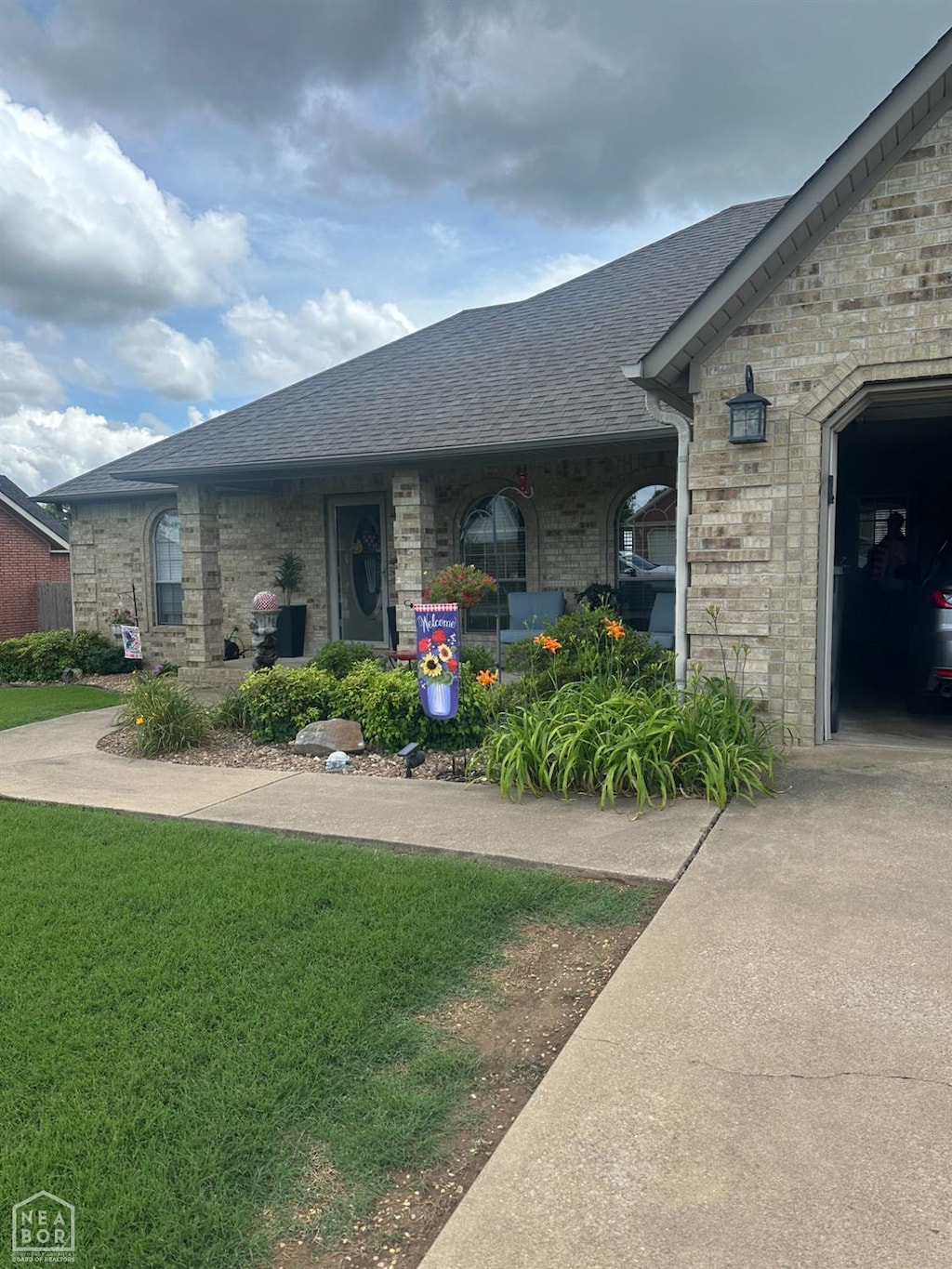 3006 Canterbury, Paragould, AR 72450 - view of front of home featuring roof with shingles, brick siding, and a front lawn