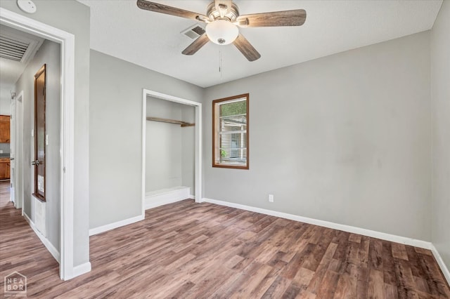 312 W College Ave, Jonesboro, AR 72401 - unfurnished bedroom featuring wood finished floors, a closet, baseboards, and ceiling fan