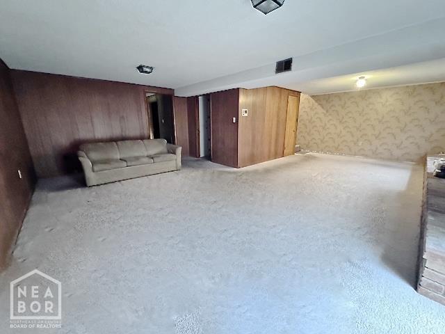 905 Locust Dr, Jonesboro, AR 72401 - unfurnished living room with wallpapered walls and wooden walls