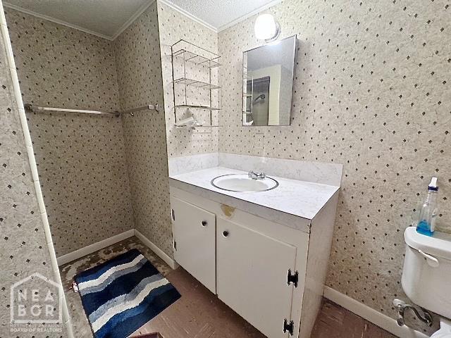 905 Locust Dr, Jonesboro, AR 72401 - bathroom featuring crown molding, vanity, toilet, wallpapered walls, and baseboards