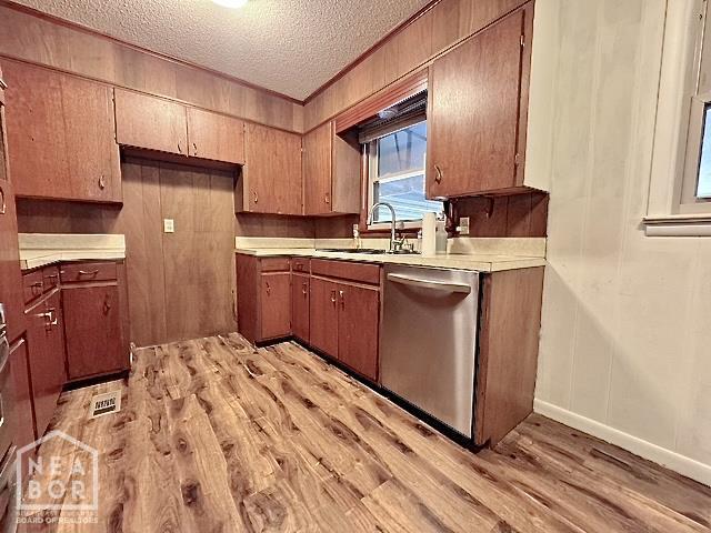 905 Locust Dr, Jonesboro, AR 72401 - kitchen featuring dishwasher, a sink, light wood finished floors, a textured ceiling, and light countertops