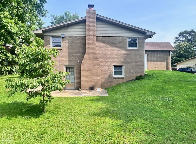 905 Locust Dr, Jonesboro, AR 72401 - back of property featuring brick siding, a chimney, and a lawn