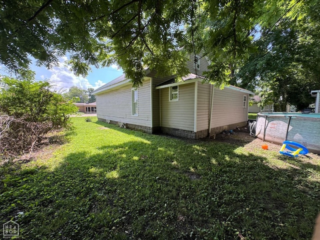 731 S Thornton Ave, Piggott, AR 72454 - view of home's exterior featuring a lawn and an outdoor pool
