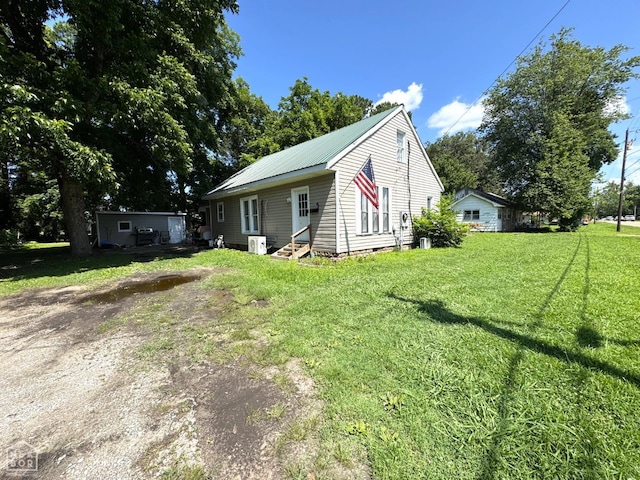 731 S Thornton Ave, Piggott, AR 72454 - view of front of home featuring entry steps, a front lawn, and a metal roof