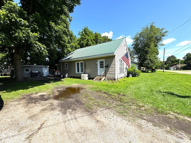 731 S Thornton Ave, Piggott, AR 72454 - bungalow-style home featuring entry steps, a front yard, and a metal roof