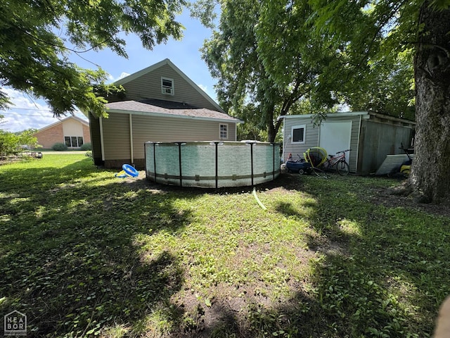 731 S Thornton Ave, Piggott, AR 72454 - view of grassy yard featuring an outdoor pool and a shed