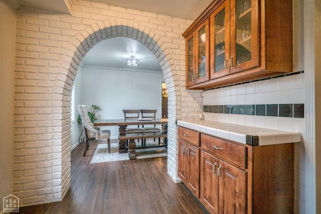 1721 W Main Extended, Trumann, AR 72472 - kitchen with dark wood-style floors, brown cabinetry, ornamental molding, and tile counters