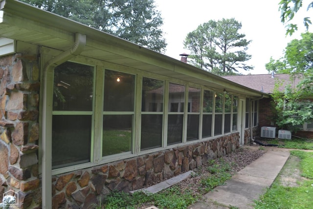 1808 Roy St, Jonesboro, AR 72401 - view of home's exterior with stone siding, a sunroom, and a chimney