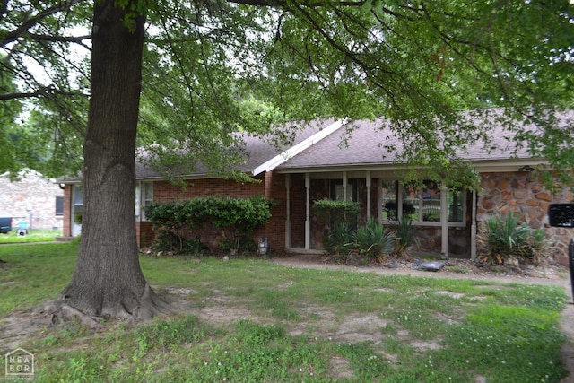 1808 Roy St, Jonesboro, AR 72401 - view of front of house featuring roof with shingles, brick siding, and a front lawn