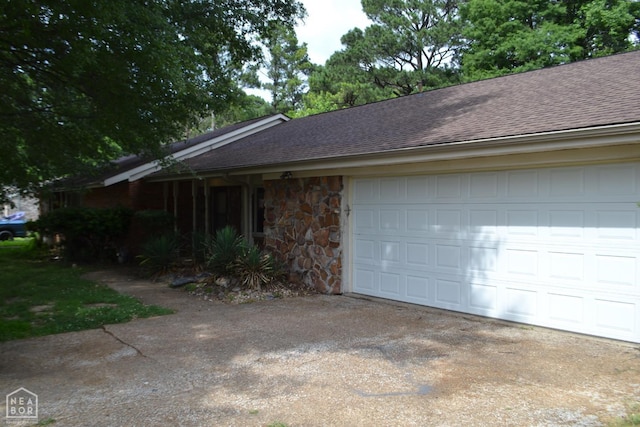 1808 Roy St, Jonesboro, AR 72401 - view of home's exterior with roof with shingles, stone siding, a garage, and driveway