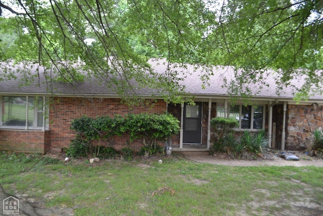 1808 Roy St, Jonesboro, AR 72401 - ranch-style home with a front yard, brick siding, roof with shingles, and stone siding