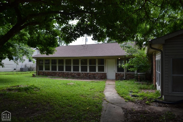 1808 Roy St, Jonesboro, AR 72401 - back of house with stone siding, a lawn, and roof with shingles