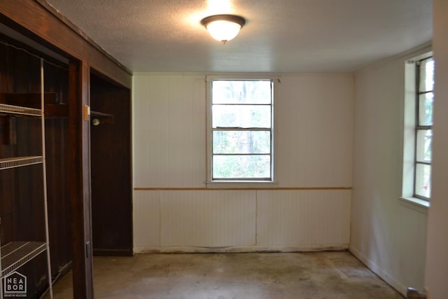 1808 Roy St, Jonesboro, AR 72401 - unfurnished bedroom featuring concrete floors, wood walls, and a textured ceiling
