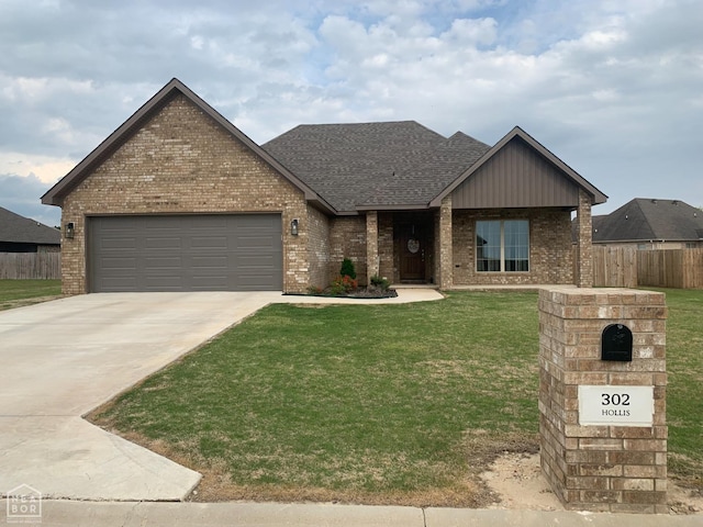 302 Hollis St, Bono, AR 72416 - view of front facade with an attached garage, brick siding, fence, and a front lawn