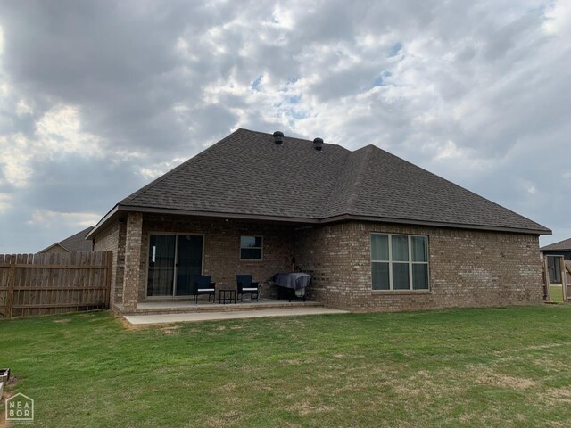 302 Hollis St, Bono, AR 72416 - back of house with brick siding, fence, a patio area, and a lawn