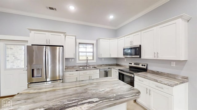 527 Annsley Ln, Manila, AR 72442 - kitchen featuring appliances with stainless steel finishes, a sink, light stone countertops, white cabinetry, and ornamental molding