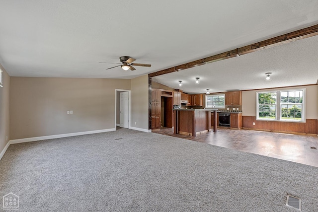 338 Buttercup Ln, Manila, AR 72442 - unfurnished living room with carpet, a ceiling fan, vaulted ceiling, wine cooler, and wooden walls