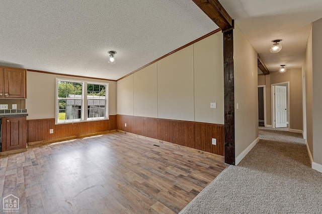 338 Buttercup Ln, Manila, AR 72442 - unfurnished living room with lofted ceiling, wood finished floors, wainscoting, a textured ceiling, and wood walls