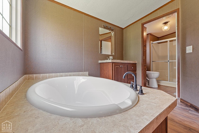 338 Buttercup Ln, Manila, AR 72442 - bathroom featuring a stall shower, vanity, wood finished floors, a tub, and a textured ceiling
