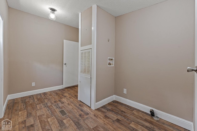 338 Buttercup Ln, Manila, AR 72442 - laundry room featuring hookup for a washing machine, a heating unit, wood finished floors, and a textured ceiling
