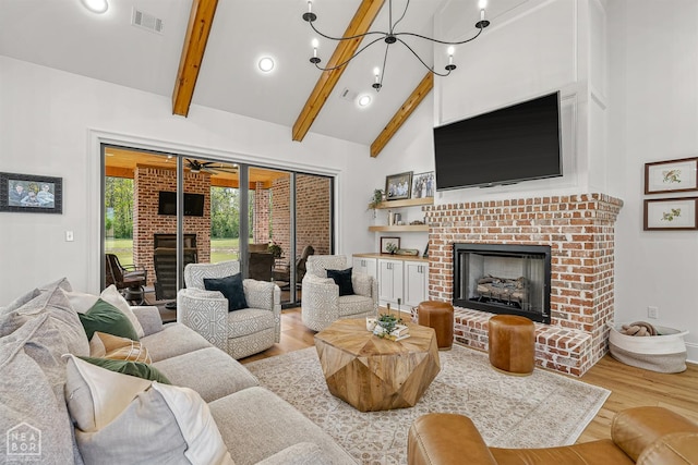 126 County Road 7459, Jonesboro, AR 72401 - living area featuring a fireplace, wood finished floors, beamed ceiling, high vaulted ceiling, and ceiling fan