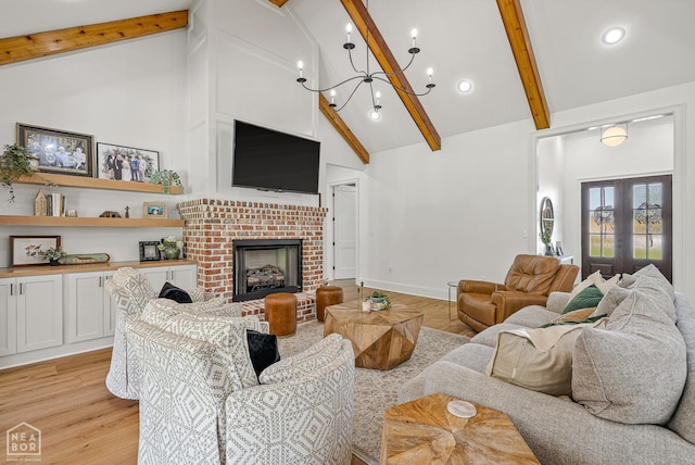 126 County Road 7459, Jonesboro, AR 72401 - living area featuring high vaulted ceiling, beamed ceiling, light wood-type flooring, a chandelier, and a fireplace