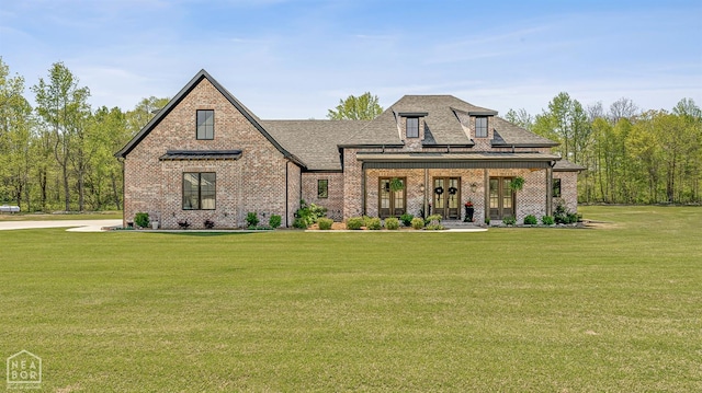 126 County Road 7459, Jonesboro, AR 72401 - french country style house featuring brick siding, a front yard, roof with shingles, and french doors