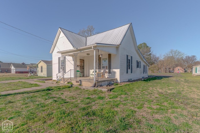 view of front facade with metal roof, a front lawn, and covered porch