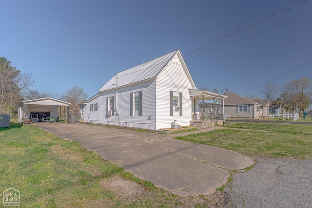view of front of house featuring an outdoor structure, a front lawn, a porch, a garage, and metal roof