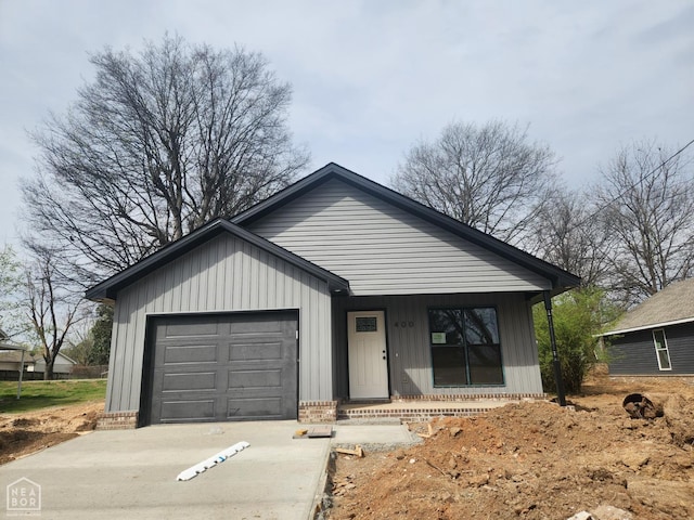 view of front of property featuring brick siding, a garage, and concrete driveway