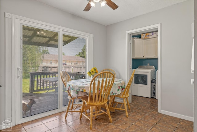 dining space with dark tile patterned floors, washer / dryer, ceiling fan, and baseboards