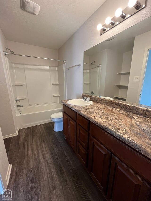 3721 Churchill Dr, Jonesboro, AR 72404 - bathroom featuring wood finished floors, toilet, vanity, bathtub / shower combination, and a textured ceiling