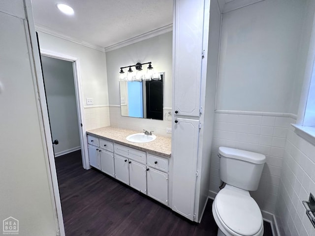 420 N 12th Ave, Piggott, AR 72454 - bathroom with wood finished floors, vanity, tile walls, crown molding, and a wainscoted wall