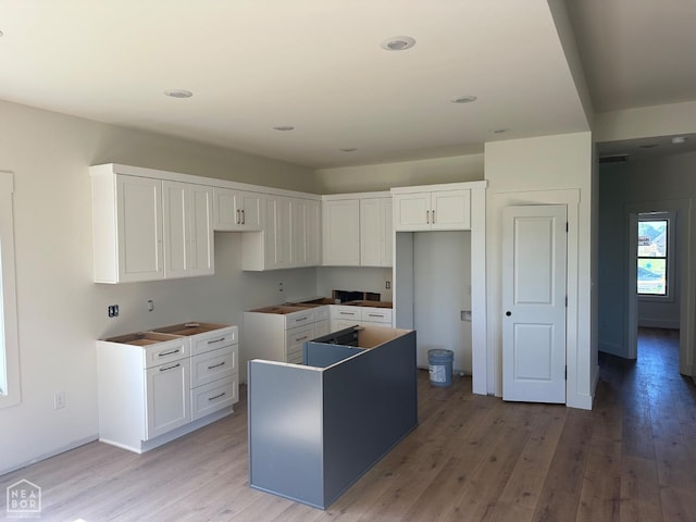 129 Hidden Creek Dr, Brookland, AR 72417 - kitchen with a center island, light wood-style flooring, white cabinetry, recessed lighting, and baseboards