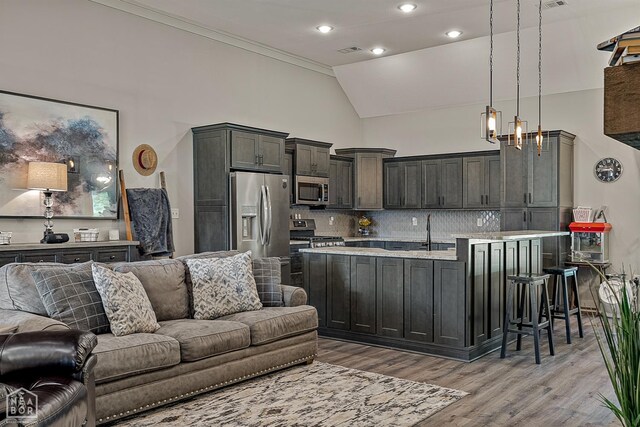 2720 Paradise Hills Ln, Jonesboro, AR 72405 - kitchen featuring stainless steel appliances, open floor plan, light countertops, light wood-type flooring, and backsplash