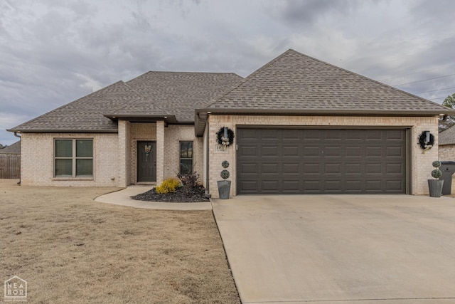 1011 S 59th St S, Paragould, AR 72450 - french provincial home featuring a shingled roof, brick siding, and concrete driveway
