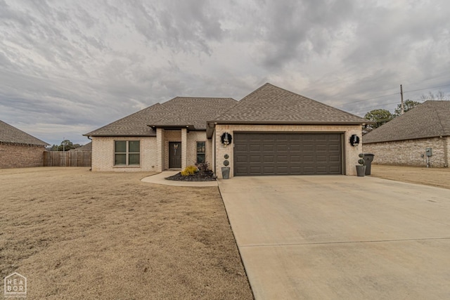 1011 S 59th St S, Paragould, AR 72450 - view of front of house featuring a garage, a shingled roof, brick siding, and driveway
