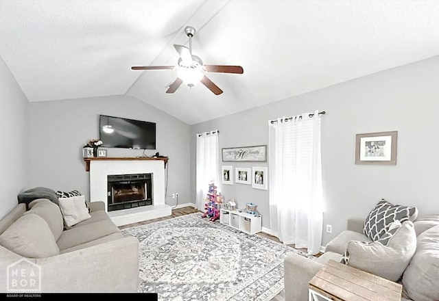 199 County Road 305, Jonesboro, AR 72401 - living area featuring a fireplace with raised hearth, wood finished floors, a ceiling fan, baseboards, and lofted ceiling